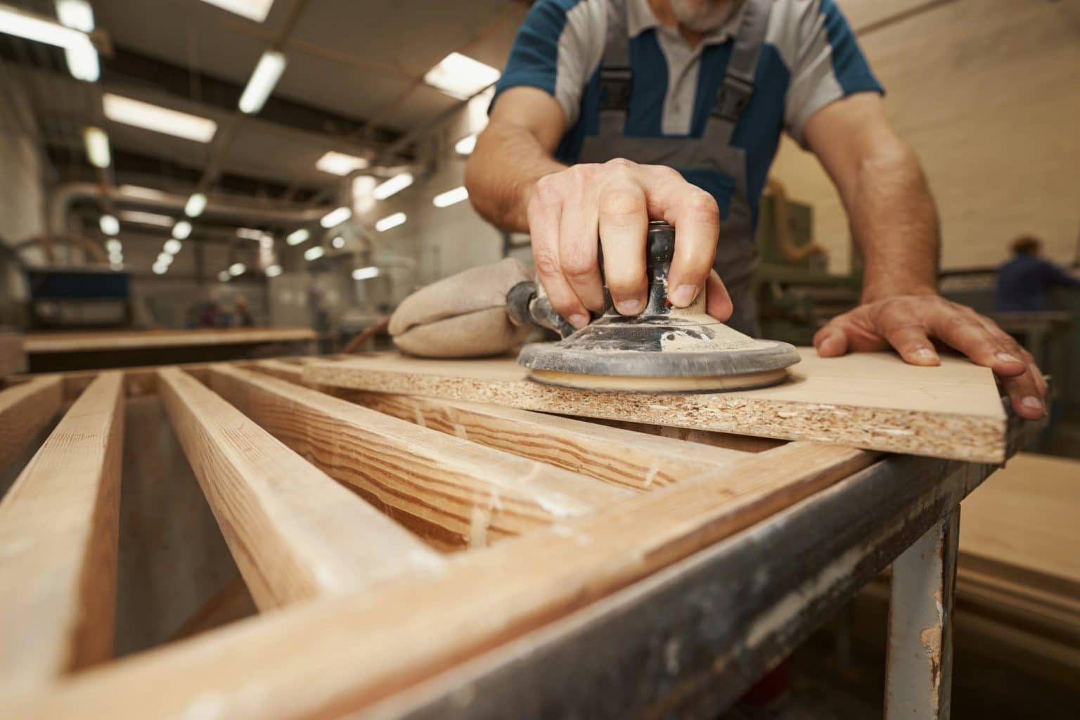 Close up of male hand grinding mdf plate