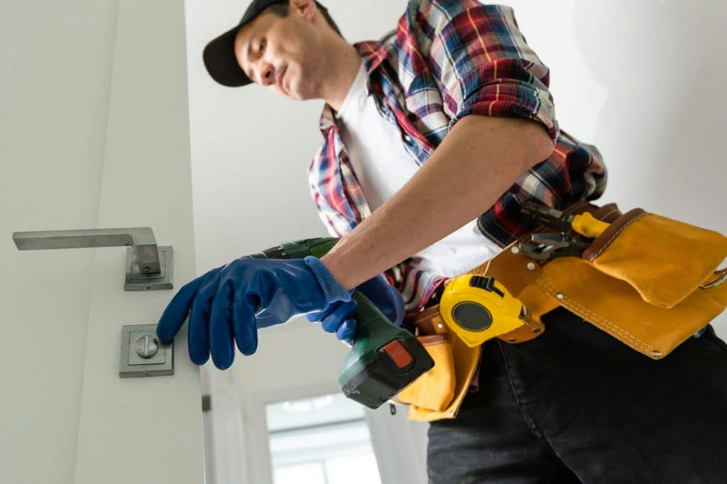 Man removing lock from door