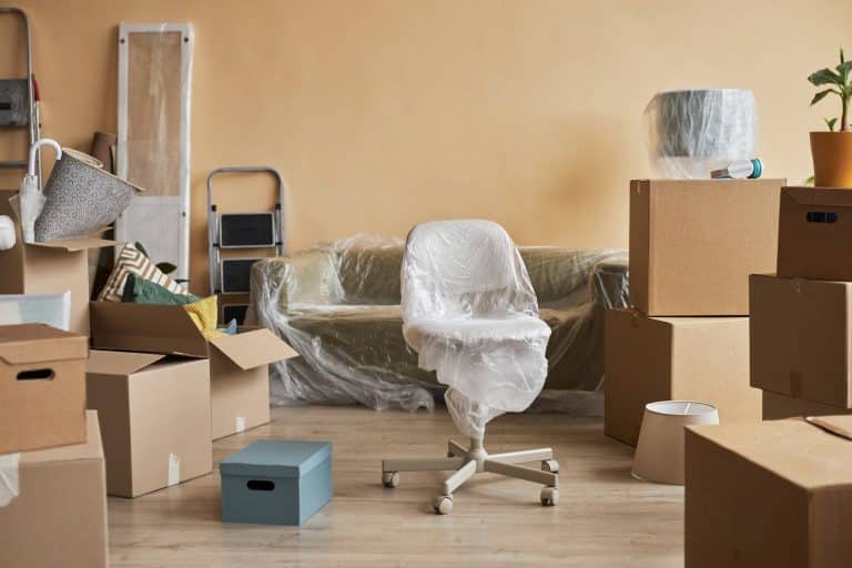 Part of living room of new apartment with furniture wrapped into cellophane