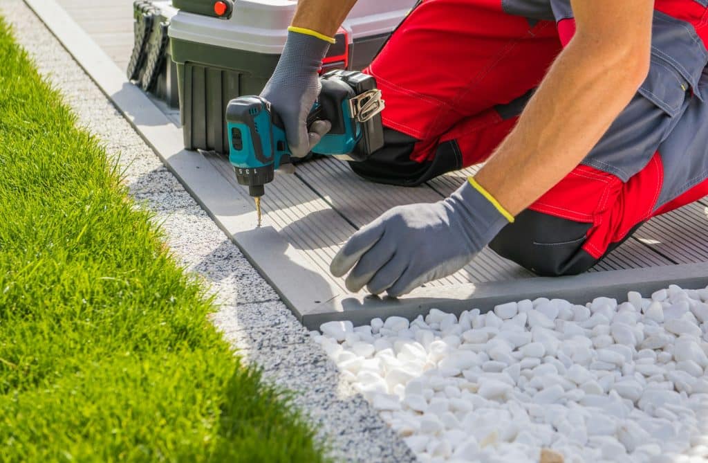 Professional Worker Installing Poolside Composite Material Deck