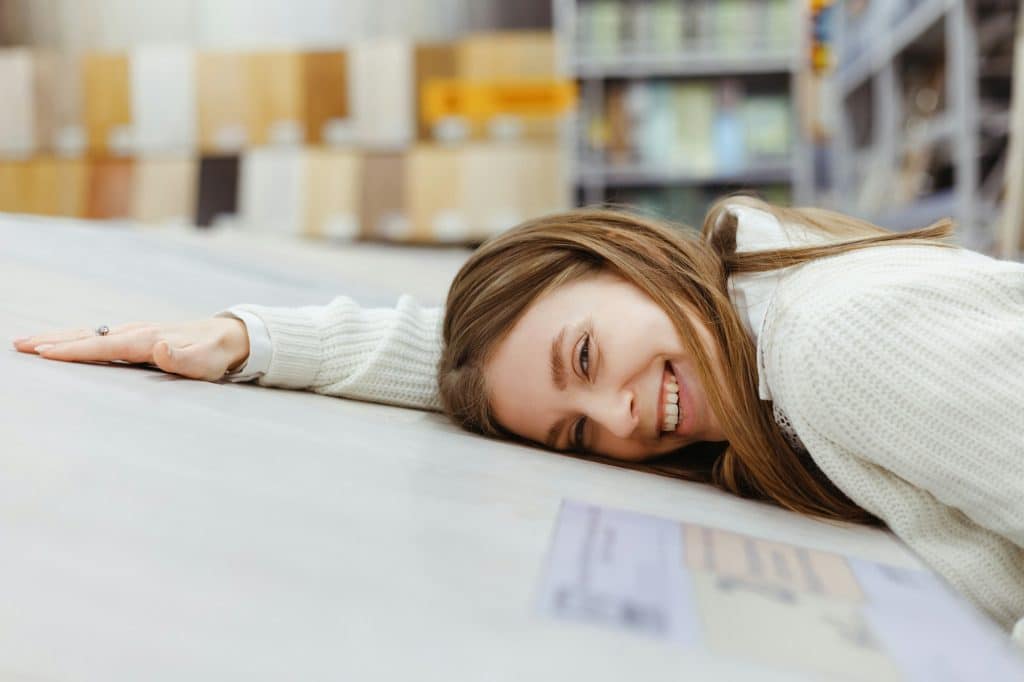 Woman choosing laminate floor for home renovation. In love with natural tactile materials